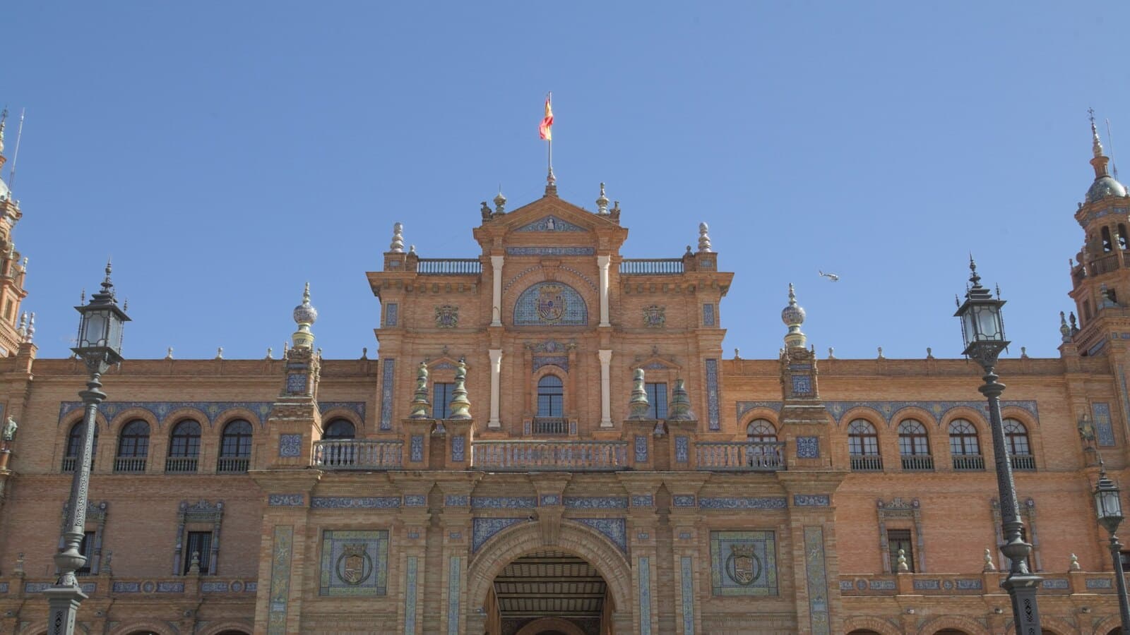 The tiled brick façade, arcades and towers of the Plaza de España in Seville.